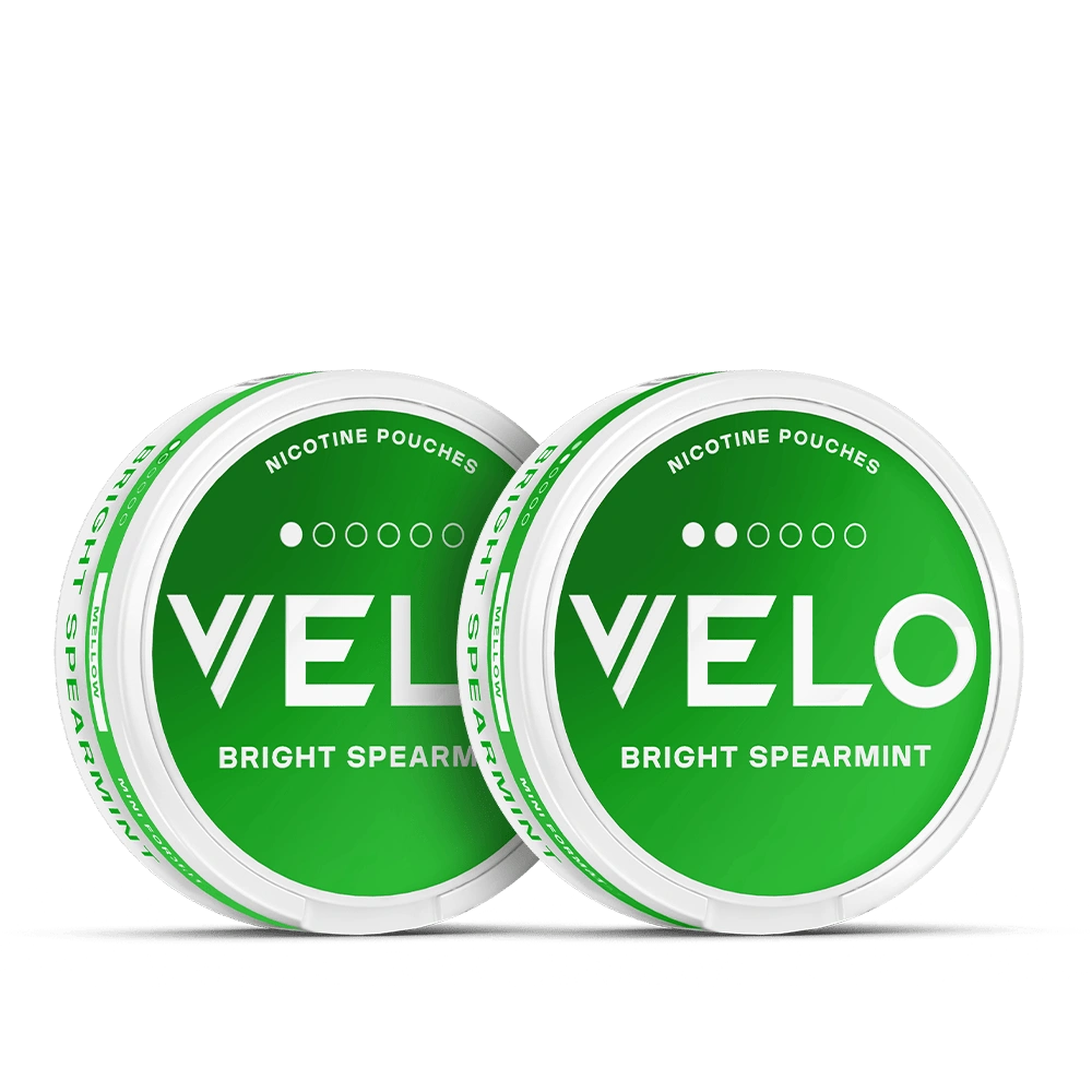 Velo Nicotine Pouches |  Two round white tins with bright green labels read VELO Bright Spearmint and Nicotine Pouches. The Velo tins are placed side by side, slightly overlapping against a white background, highlighting the fresh appeal of these nicotine pouches.