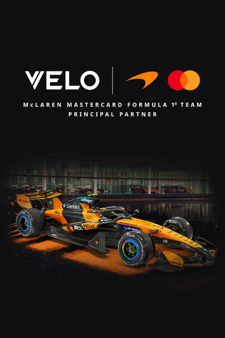 Velo Nicotine Pouches |  A McLaren Formula 1 car with VELO, Mastercard, and McLaren logos above it highlights the VELO brand’s presence as a principal partner. The text reads “McLaren Mastercard Formula 1 Team Principal Partner.” The car features a striking black and orange livery, reflecting VELO’s innovative approach to nicotine pouches.