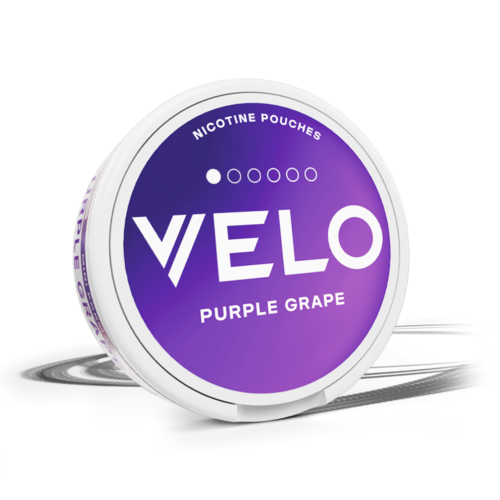 Velo Nicotine Pouches |  A round container of VELO Purple Grape nicotine pouches with a purple gradient lid and bold white text, showcasing Velo’s innovative approach to nicotine enjoyment.