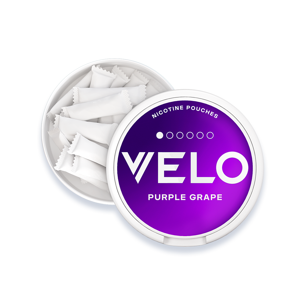 Velo Nicotine Pouches |  A round container labeled VELO Purple Grape Nicotine Pouches is open, showing several white nicotine pouches inside on a white background.