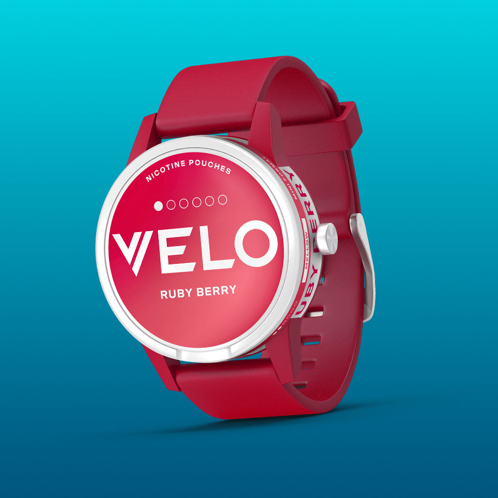 Velo Nicotine Pouches |  A red smartwatch with a round face displaying Velo Ruby Berry nicotine pouches against a blue gradient background. The watch has a bold, modern design with white text on the dial, highlighting the innovative appeal of Velo nicotine pouches.