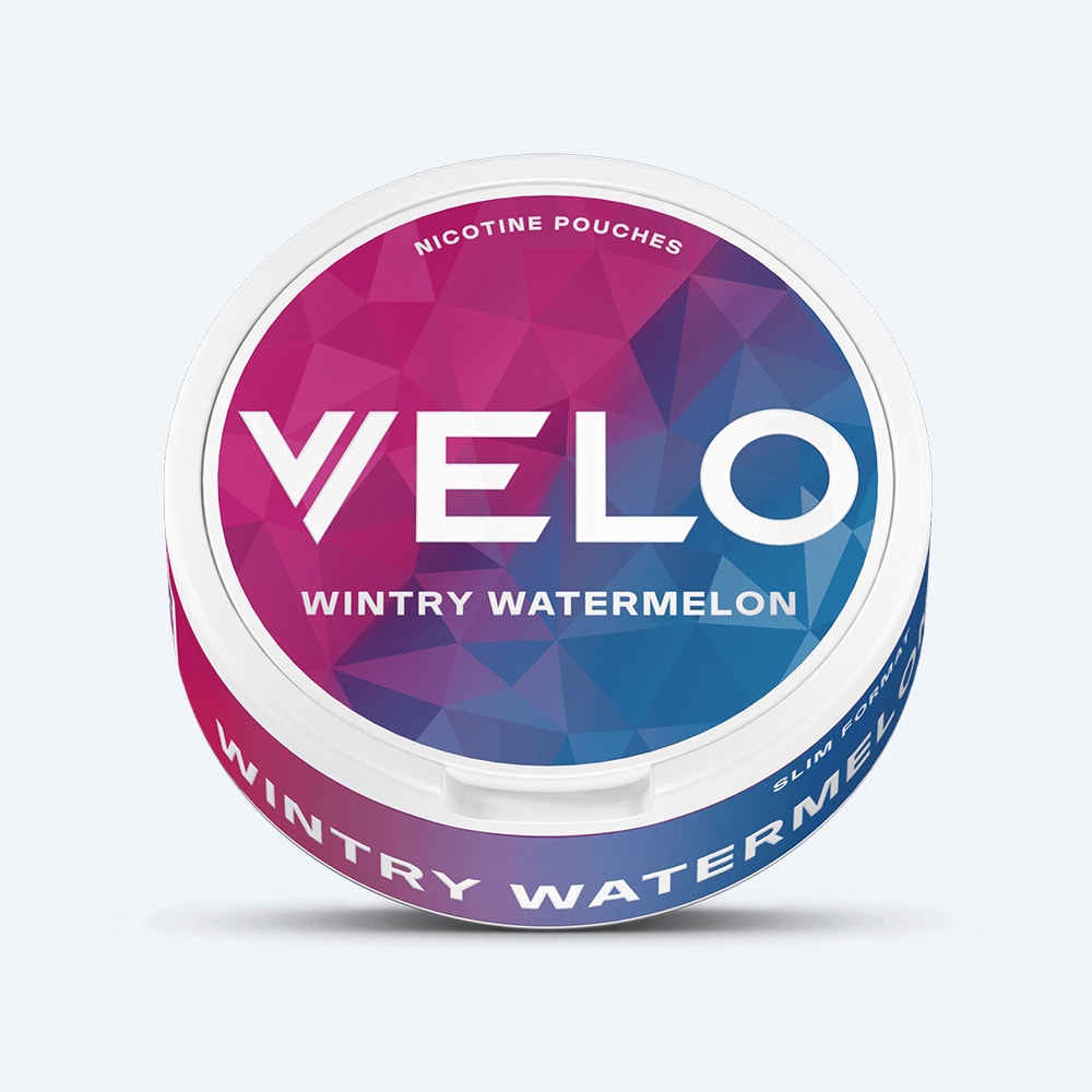 Velo Nicotine Pouches |  A round container of VELO’s Wintry Watermelon nicotine pouches, featuring a purple and blue geometric design with bold white lettering on the lid, captures the refreshing fusion of watermelon and a touch of peppermint.