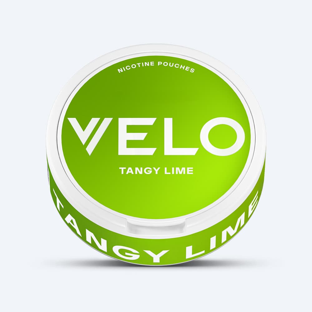 Velo Nicotine Pouches |  A round, green container of VELO Tangy Lime nicotine pouches rests on a plain white surface. The lid and side of the packaging display the brand name VELO and the flavor Tangy Lime in bold white text, emphasizing the zesty zing of citrus lime.