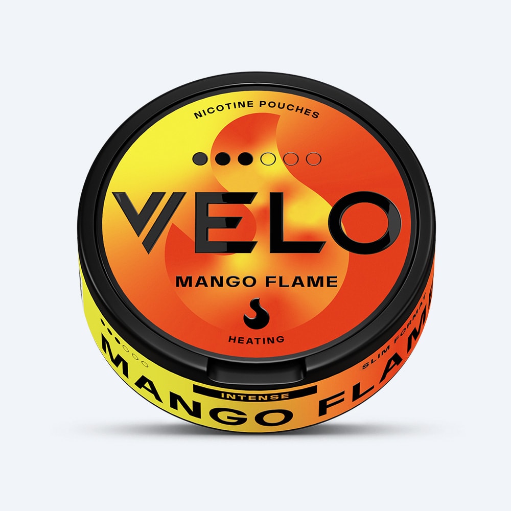 Velo Nicotine Pouches |  Experience the bold taste of VELO Mango Flame nicotine pouches, presented in a round container with a vibrant yellow-orange gradient design, striking black text, and an eye-catching flame graphic on the lid. Enjoy the ripe mango flavor combined with an intense burning sensation for a truly invigorating and daring experience.