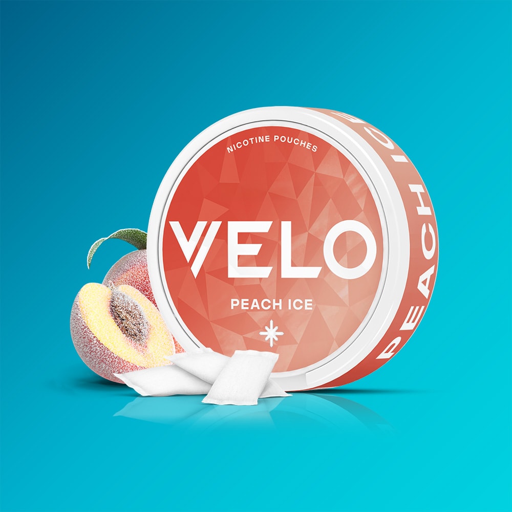 Velo Nicotine Pouches |  A round canister of VELO Peach Ice is displayed with white nicotine pouches in front. Next to the container are a peach with a leaf and several ice cubes, all arranged against a blue gradient background that highlights the crisp refreshment of VELO's Peach Ice flavor.