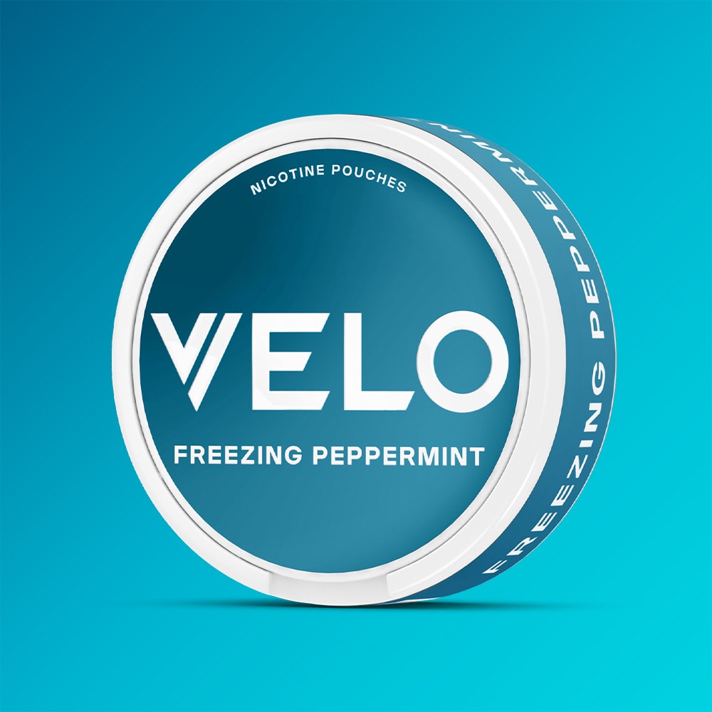 Velo Nicotine Pouches |  A round container of VELO Freezing Peppermint Nicotine Pouches, featuring a blue and white design and set against a blue gradient background, highlights the powerful, refreshing flavor of VELO’s strongest menthol blend.