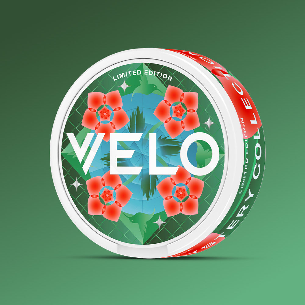 Velo Nicotine Pouches |  Round white container of VELO Mystery Collection 2 nicotine pouches with a green patterned lid featuring red flowers and the word VELO in large white letters.