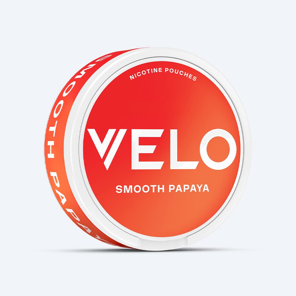 Velo Nicotine Pouches |  A round white container labeled “VELO Smooth Papaya” features a red-orange gradient lid with bold white text, displayed against a plain light background, emphasizing the tropical papaya flavor for a refreshing experience.