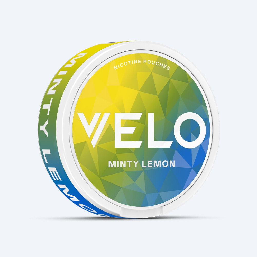 Velo Nicotine Pouches |  A round VELO Minty Lemon nicotine pouch container featuring a geometric green, yellow, and blue design with bold white text on the lid, highlighting a refreshing combination of lemon and peppermint flavors.