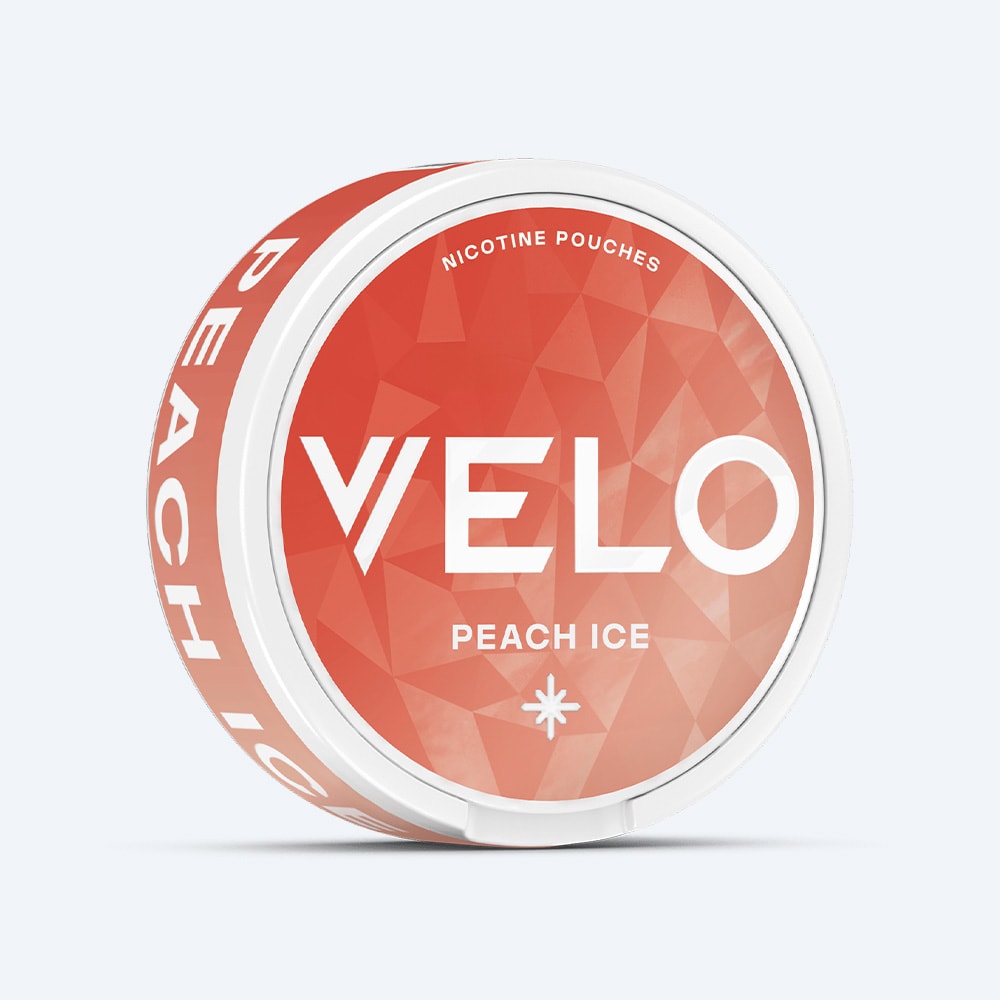 Velo Nicotine Pouches |  A round white container labeled VELO Peach Ice, featuring a peach-colored geometric pattern on the lid and "Peach Ice" text on the side, captures the refreshing vibe of an icy vape. The product is photographed against a simple, light background.