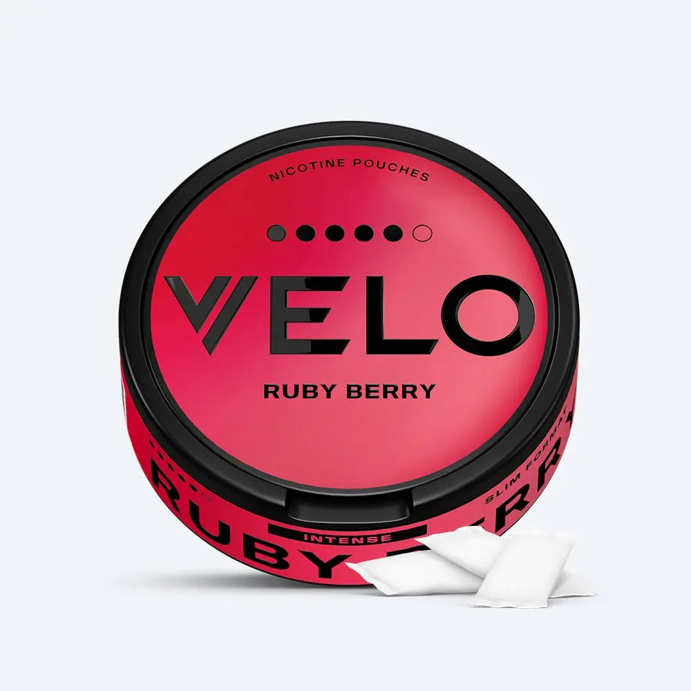 Velo Nicotine Pouches |  A round, red container labeled VELO RUBY BERRY Nicotine Pouches with two white Velo nicotine pouches placed in front of it. The design is sleek and modern.