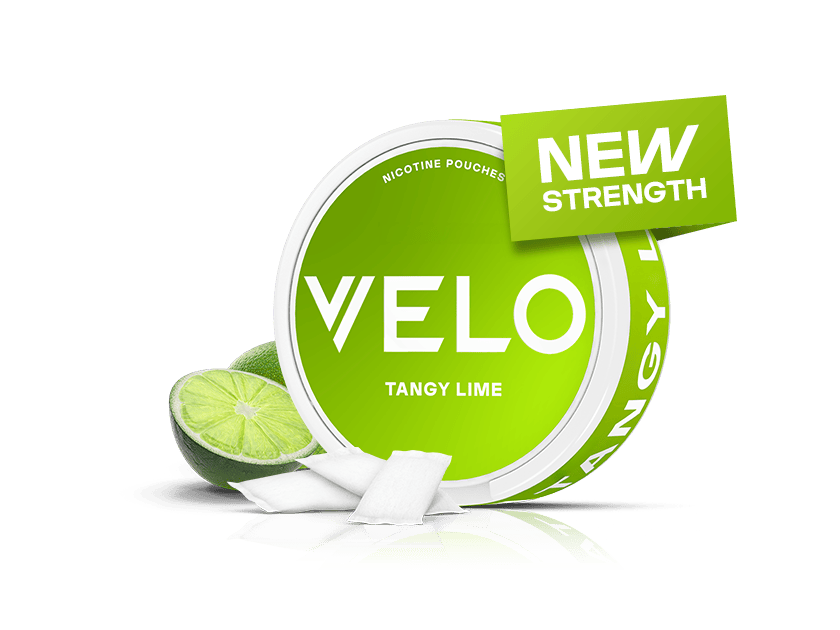 Velo Nicotine Pouches |  A round green tin labeled VELO Tangy Lime with Velo nicotine pouches, lime wedges beside it, and a green sign that says NEW STRENGTH on top. The background is white.