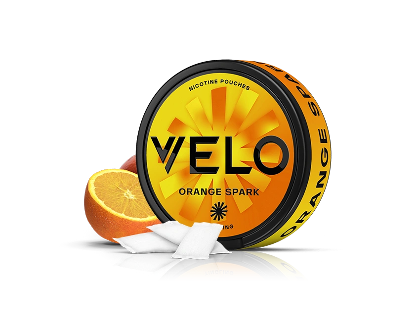 Velo Nicotine Pouches |  A round container labeled VELO Orange Spark, featuring the Velo logo, with two orange slices and three white nicotine pouches in front, on a white background. The orange and black container highlights its flavorful nicotine pouches.