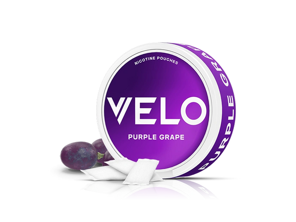 Velo Nicotine Pouches |  A round purple tin labeled VELO Purple Grape Nicotine Pouches is shown with two grapes and several small white Velo pouches in front of it, all on a white background.